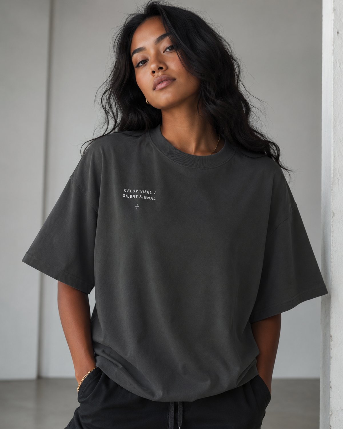 Woman wearing a charcoal oversized Celovisual T-shirt in a calm minimal streetwear look