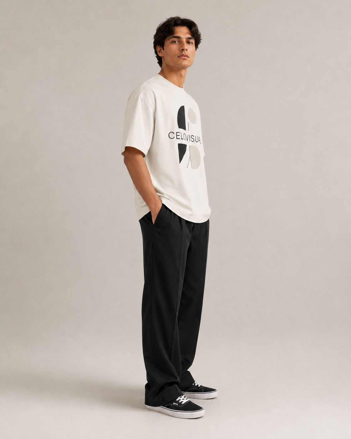 Man wearing a white t-shirt with a logo and black pants on a plain background