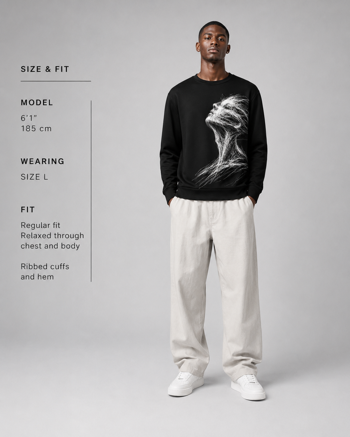 Man wearing a black sweatshirt with a graphic design on a gray background