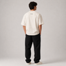 Person wearing a white t-shirt with text on the back and black pants against a gray background