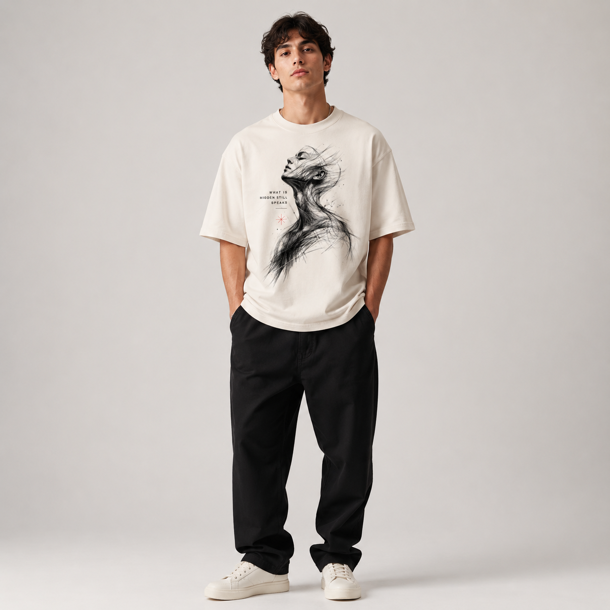 Person wearing a white t-shirt with a graphic design and black pants on a plain background