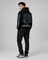 Person wearing a black hoodie with geometric designs and text on a gray background