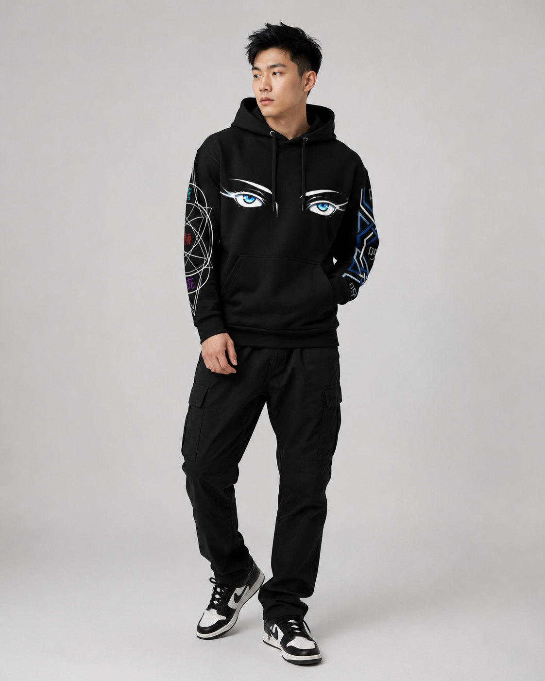 Person wearing a black hoodie with eye designs on sleeves against a gray background