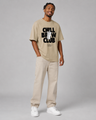 Man wearing a beige t-shirt with 'Chill Brew Club' text on a plain background