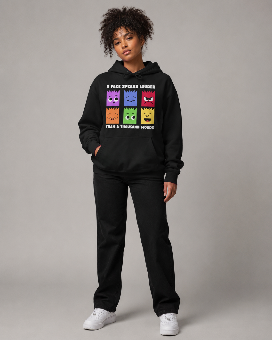 Person wearing a black hoodie with colorful graphic design on a gray background