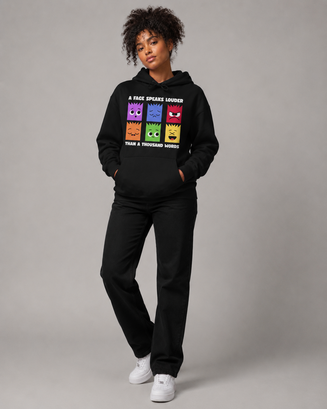 Person wearing a black hoodie with colorful graphic design on a gray background