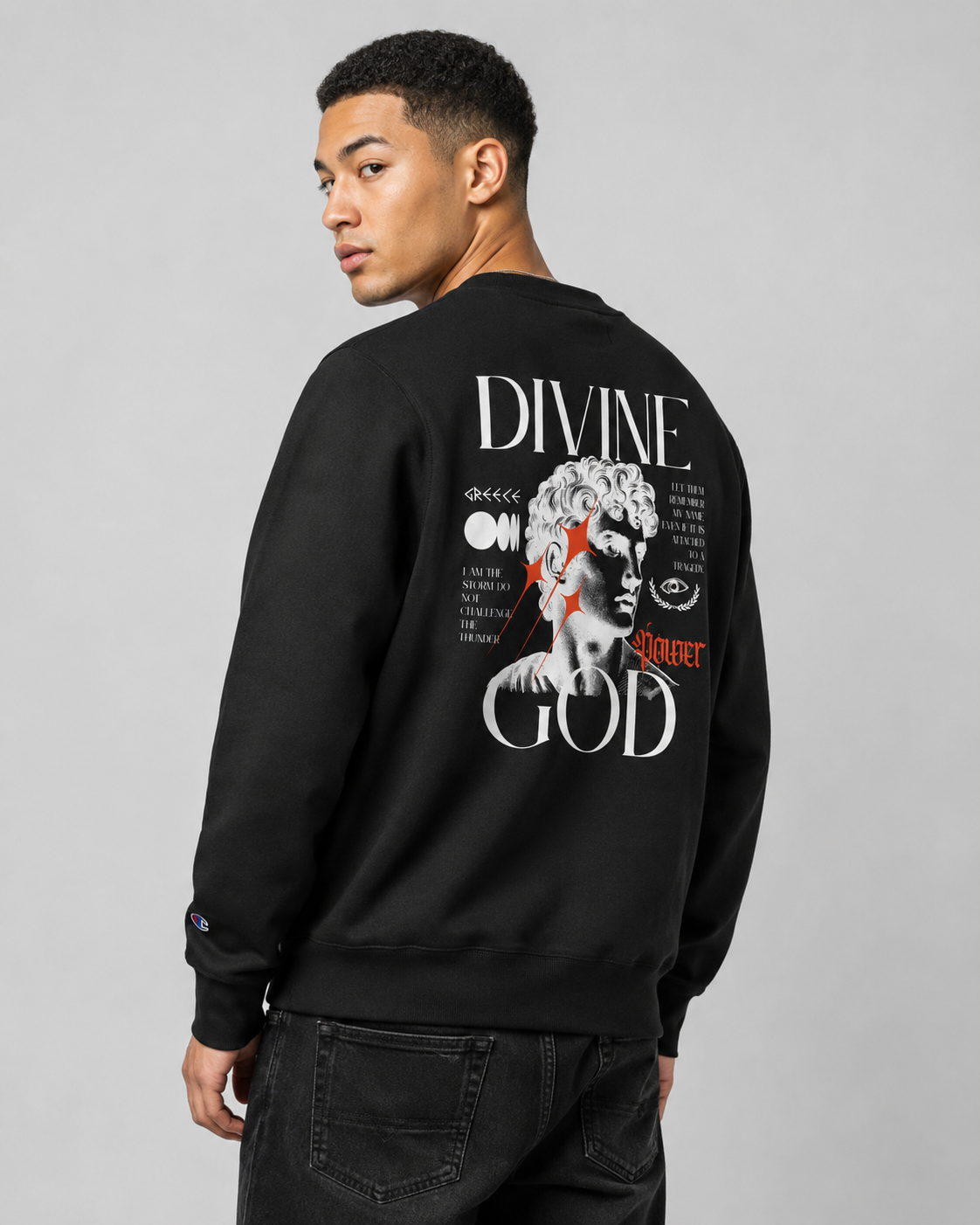 Person wearing a black sweatshirt with a graphic design on the back against a gray background