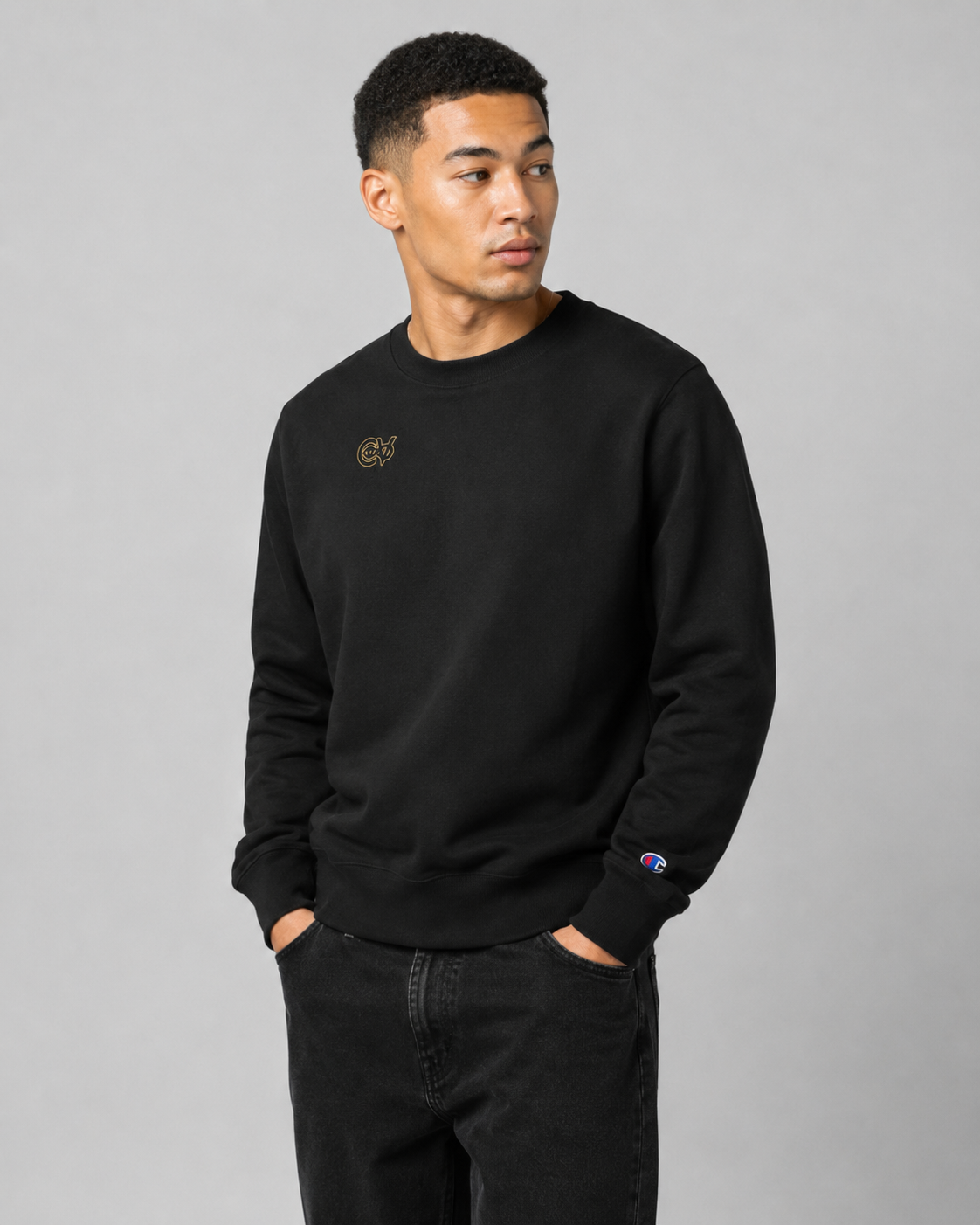 Man wearing a black sweatshirt with a logo on a gray background