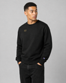 Man wearing a black sweatshirt with a logo on a gray background