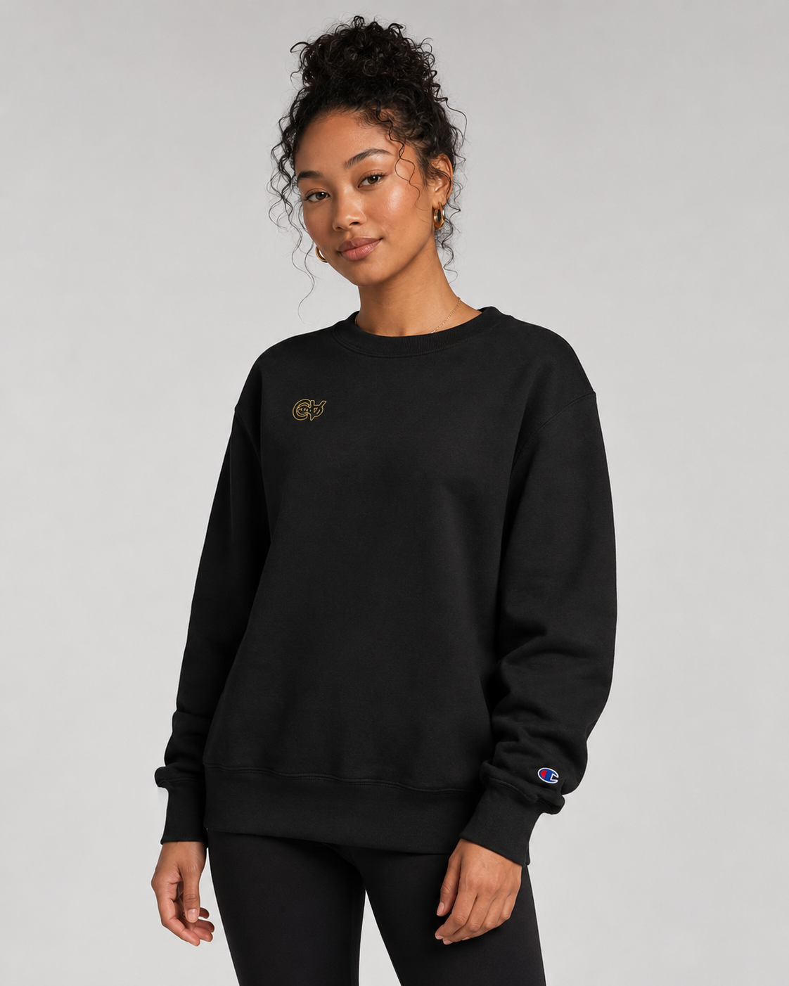 Person wearing a black sweatshirt with a logo on a gray background