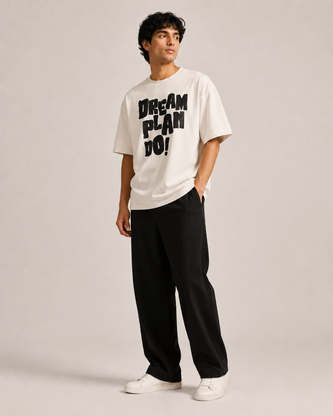 Person wearing a white t-shirt with 'Dream Plan Do!' text on a plain background