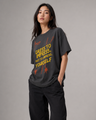Person wearing a black t-shirt with yellow and red text on a gray background