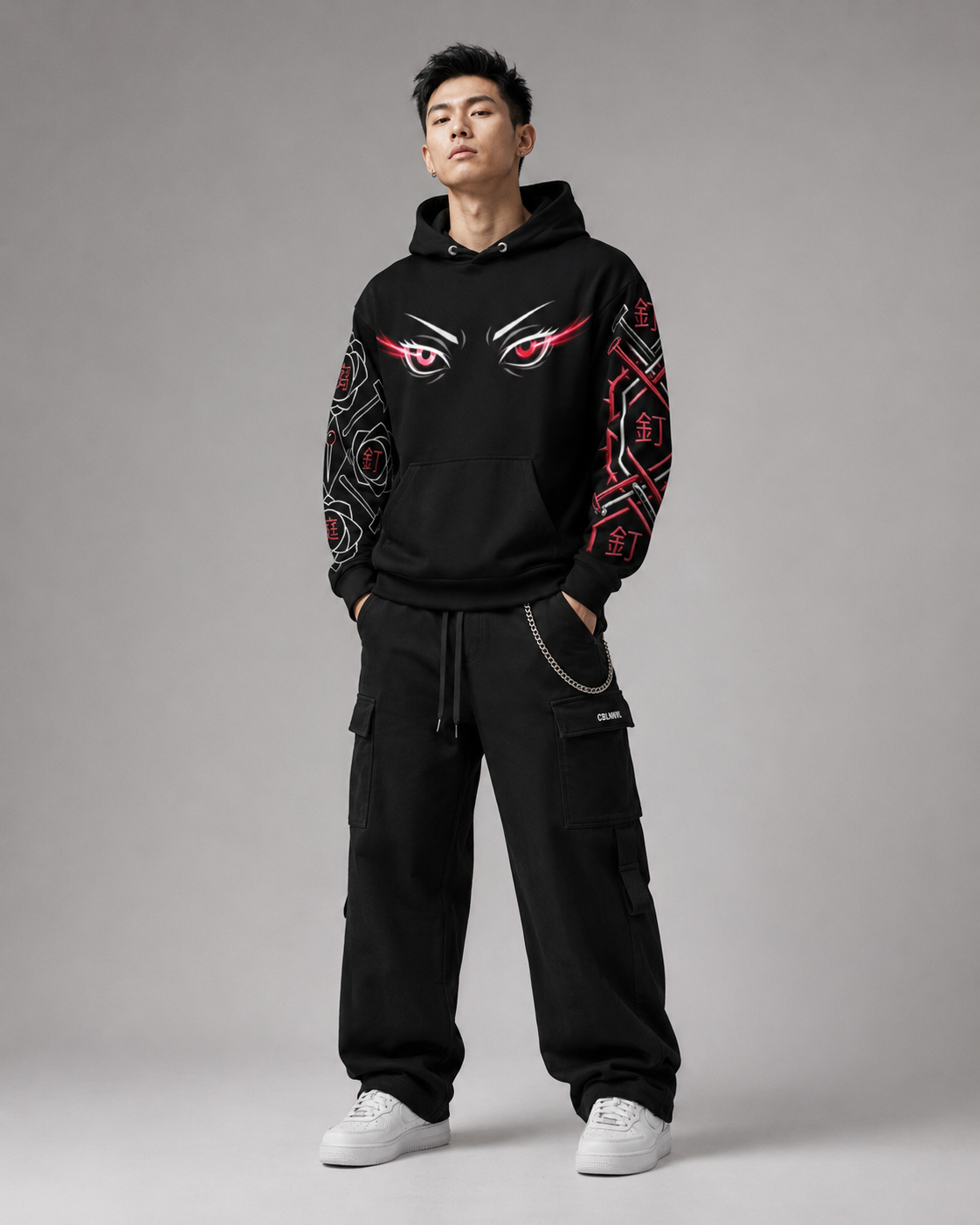 Person wearing a black hoodie with red and white designs on a gray background