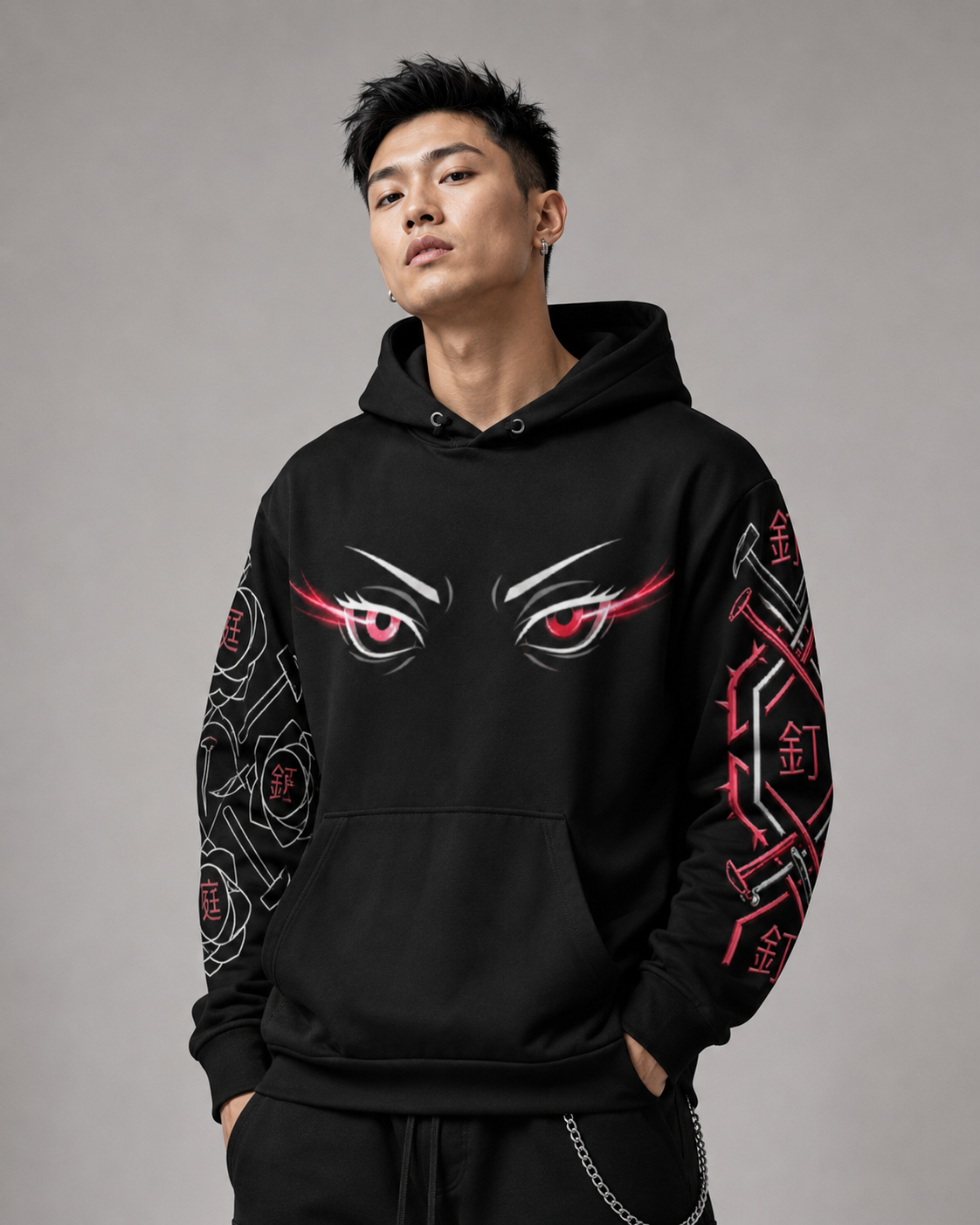 Person wearing a black hoodie with eye design and red accents on a gray background