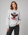 Person wearing a gray sweatshirt with a graphic design and text on a plain background