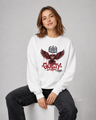 Person wearing a white sweatshirt with a graphic design and text, sitting on a white stool against a gray background.