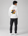 Person wearing a white hoodie with a colorful design on the back, standing against a gray background