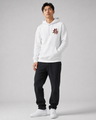 Person wearing a white hoodie with red text and black pants on a gray background