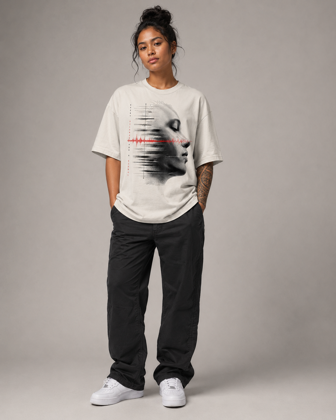 Person wearing a white t-shirt with a graphic design on a gray background