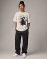 Person wearing a white t-shirt with a graphic design on a gray background