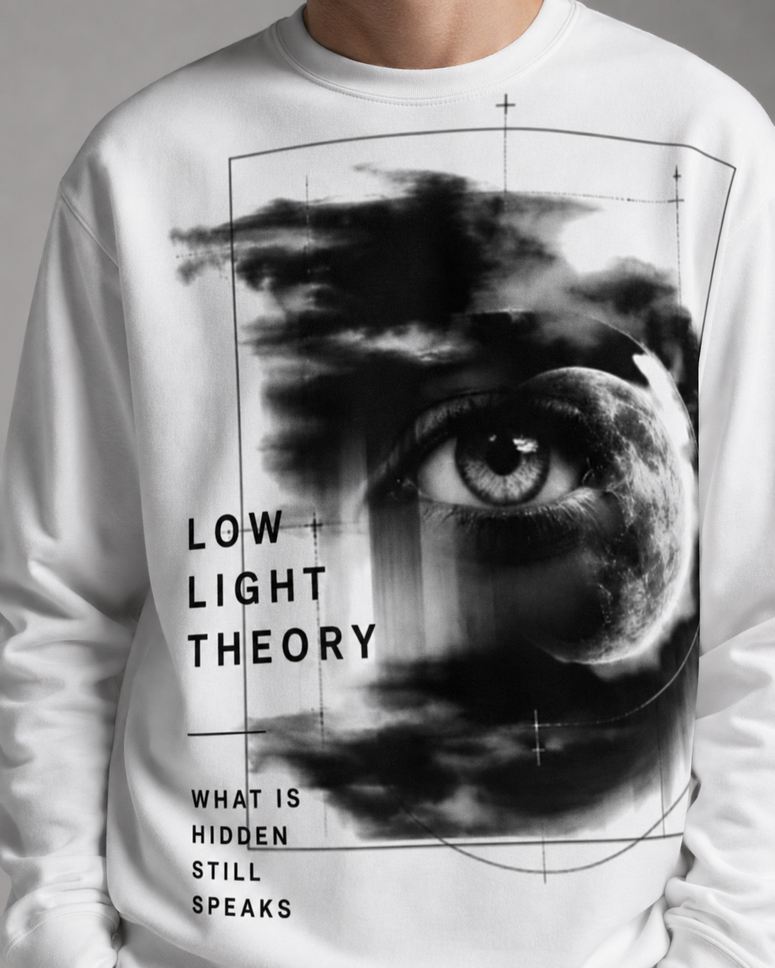 White sweatshirt with eye graphic and text 'Low Light Theory' worn by a person