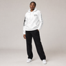 Person wearing a white hoodie with text and black pants on a light gray background