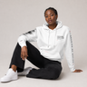 Person wearing a white hoodie with text, sitting on a light gray background