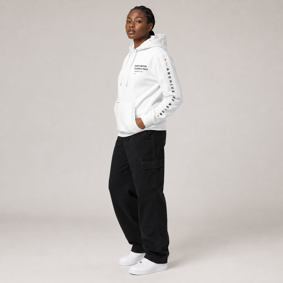 Person wearing a white hoodie and black pants on a plain background