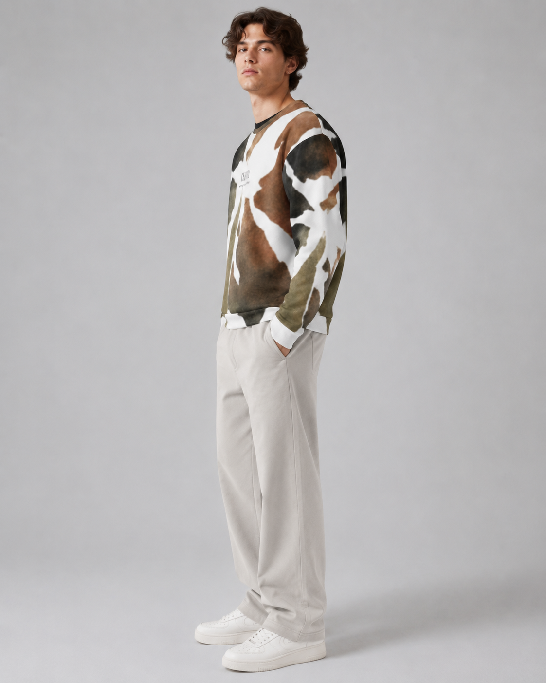 Person wearing a cow print sweater and light-colored pants on a gray background