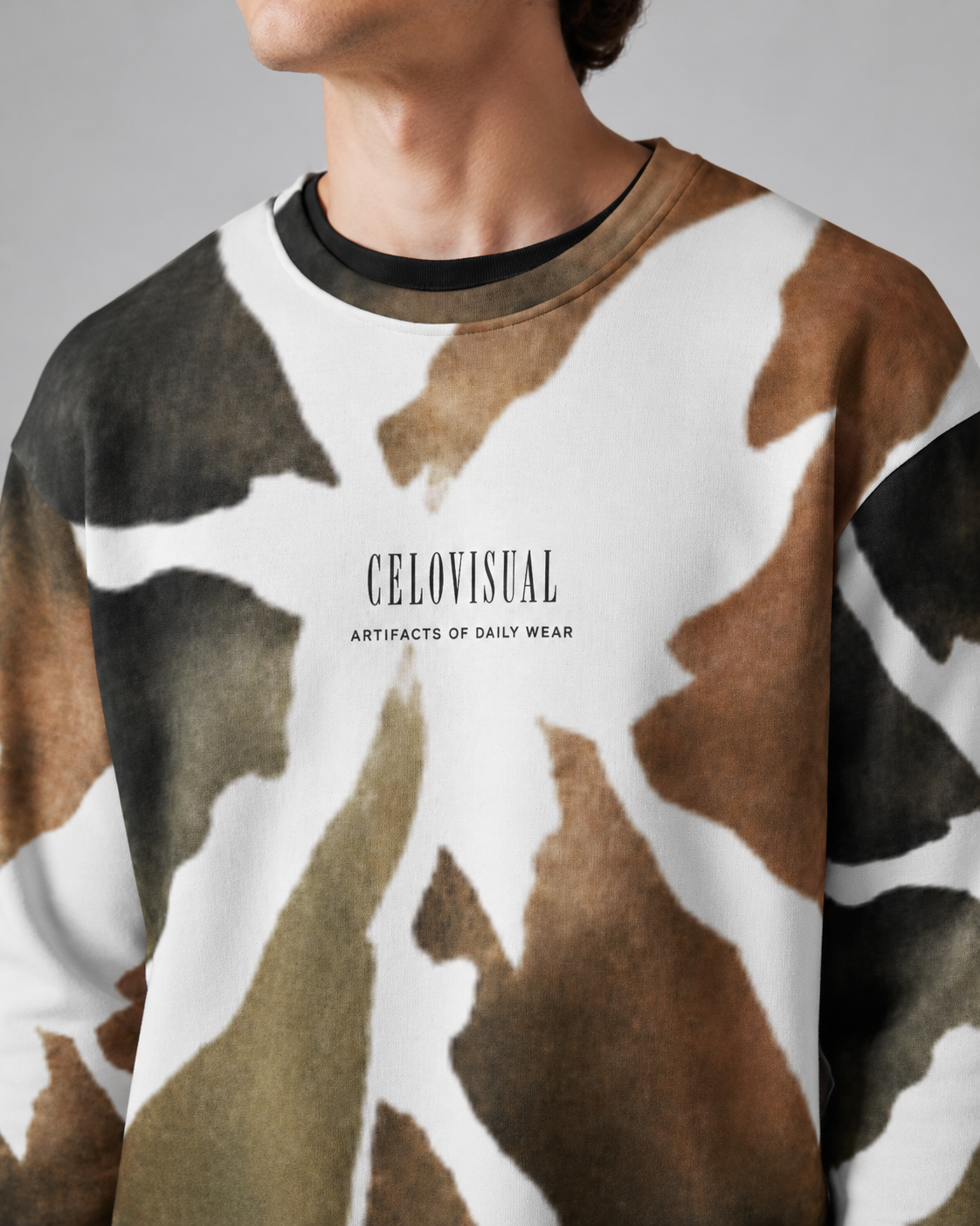 Person wearing a camouflage-patterned sweater with 'CELOVISUAL' branding.