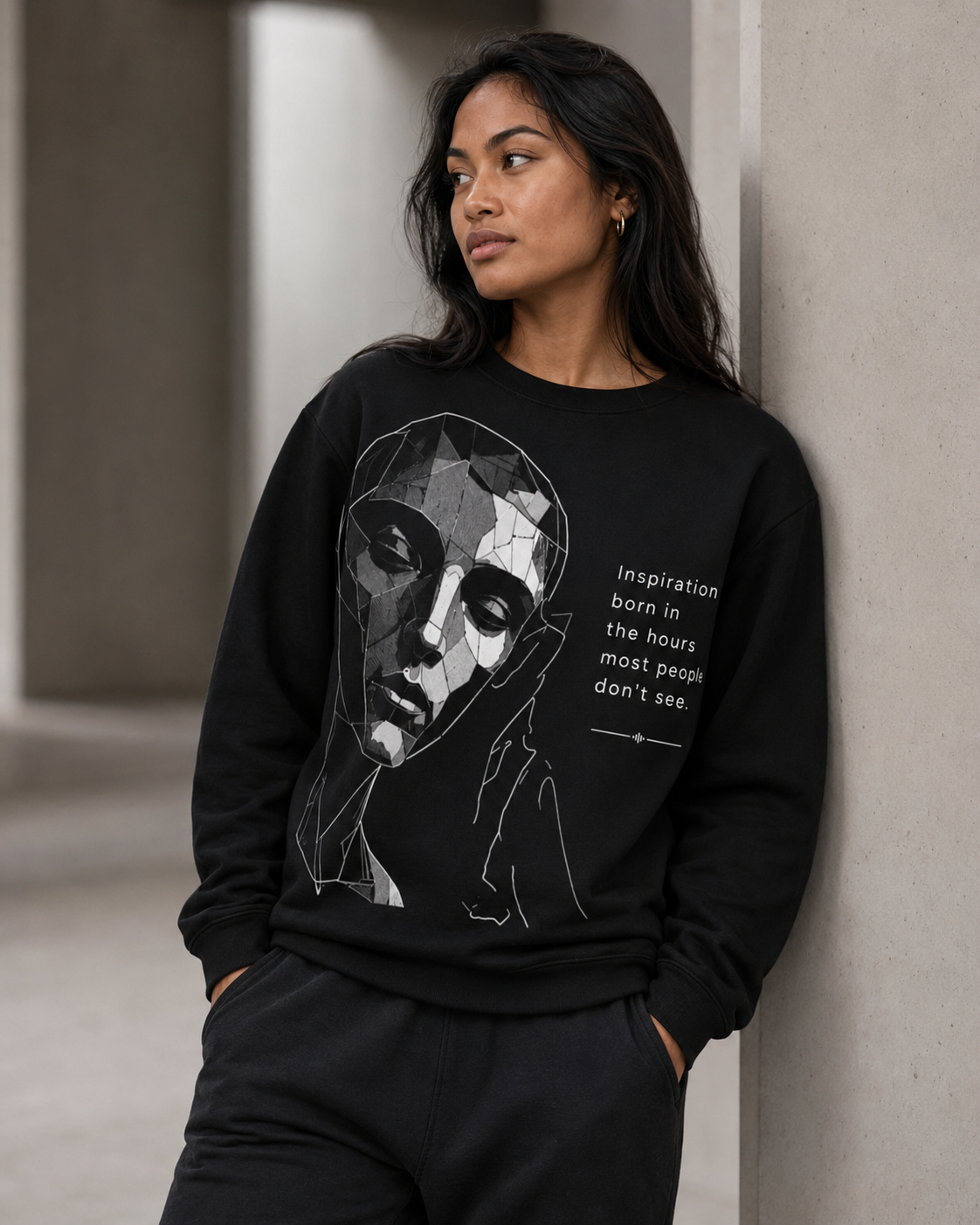 Person wearing a black sweatshirt with a graphic design and text.