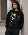 Person wearing a black sweatshirt with a graphic design and text.