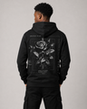 Person wearing a black hoodie with a rose design on the back against a gray background