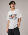 Person wearing a white t-shirt with a graphic design on a plain background