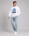 Person wearing a white sweatshirt with a graphic design and light blue jeans on a gray background