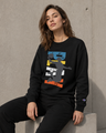 Woman wearing a black sweatshirt with a colorful graphic design against a concrete wall.