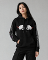 Person wearing a black hoodie with white graphic designs on a gray background