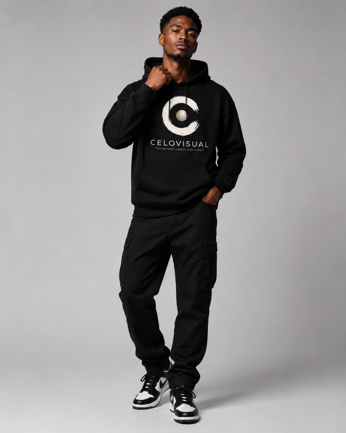 Person wearing a black hoodie with a logo and text on a gray background