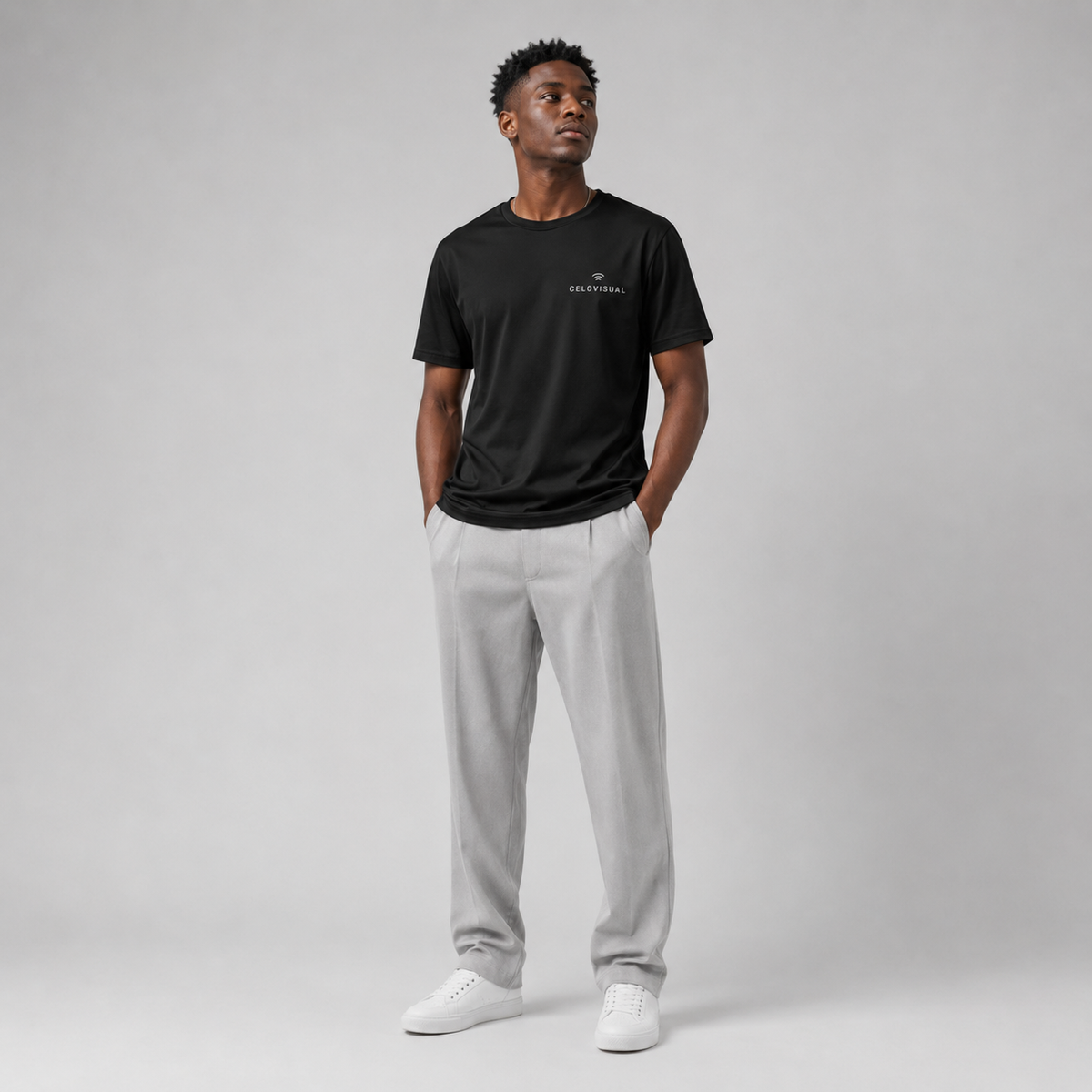 Man wearing a black t-shirt and gray pants on a gray background