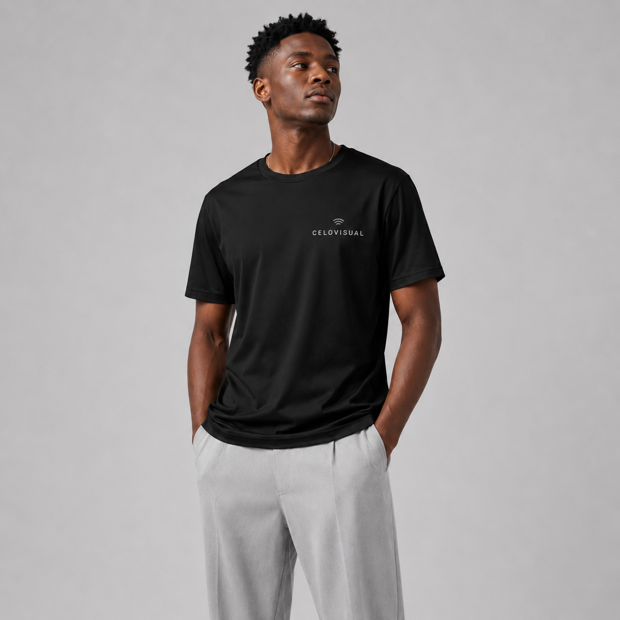 Man wearing a black t-shirt with a logo on a gray background