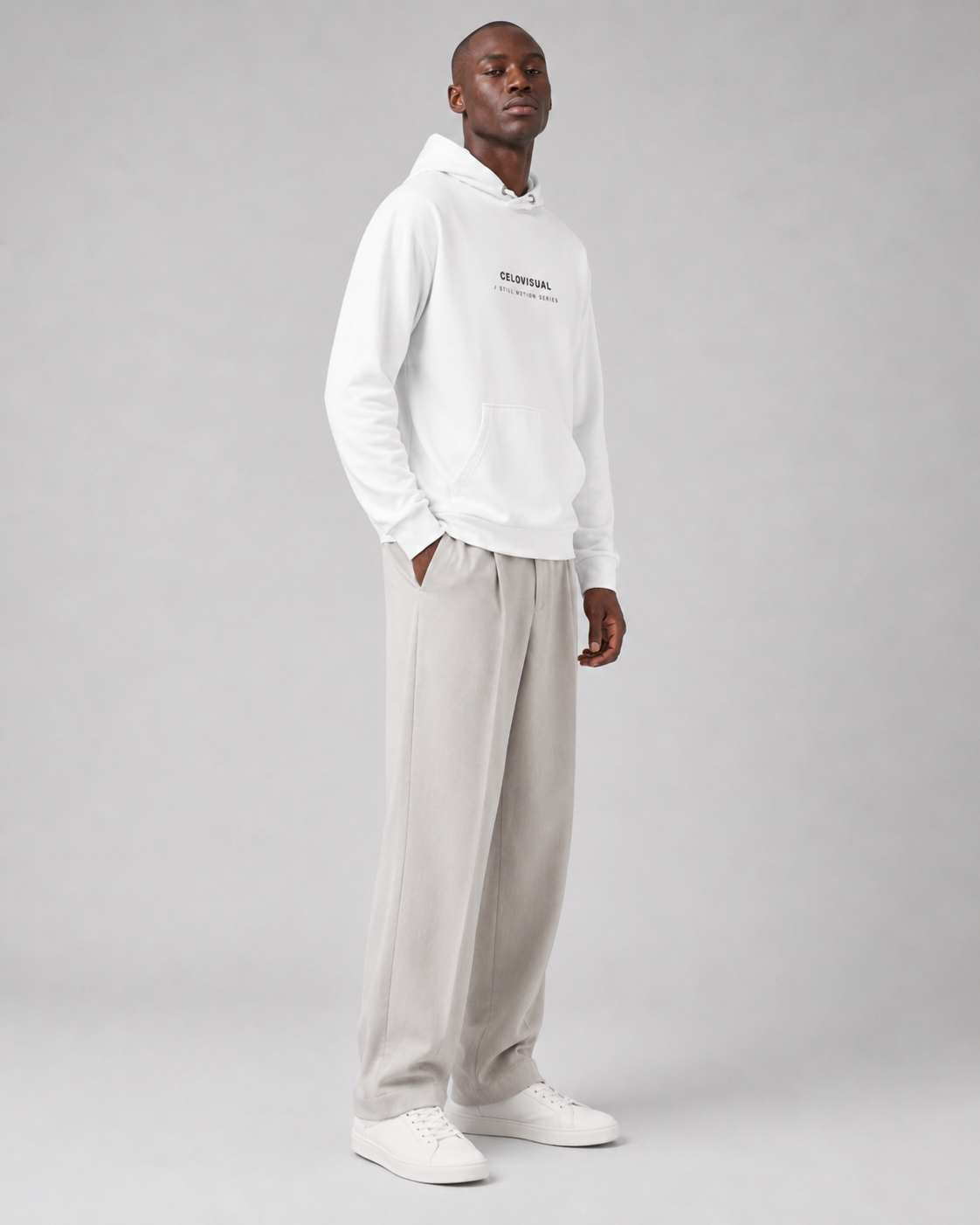 Person wearing a white hoodie and light gray pants on a plain background