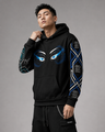 Person wearing a black hoodie with blue eye designs on a gray background