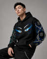 Person wearing a black hoodie with eye designs on a gray background